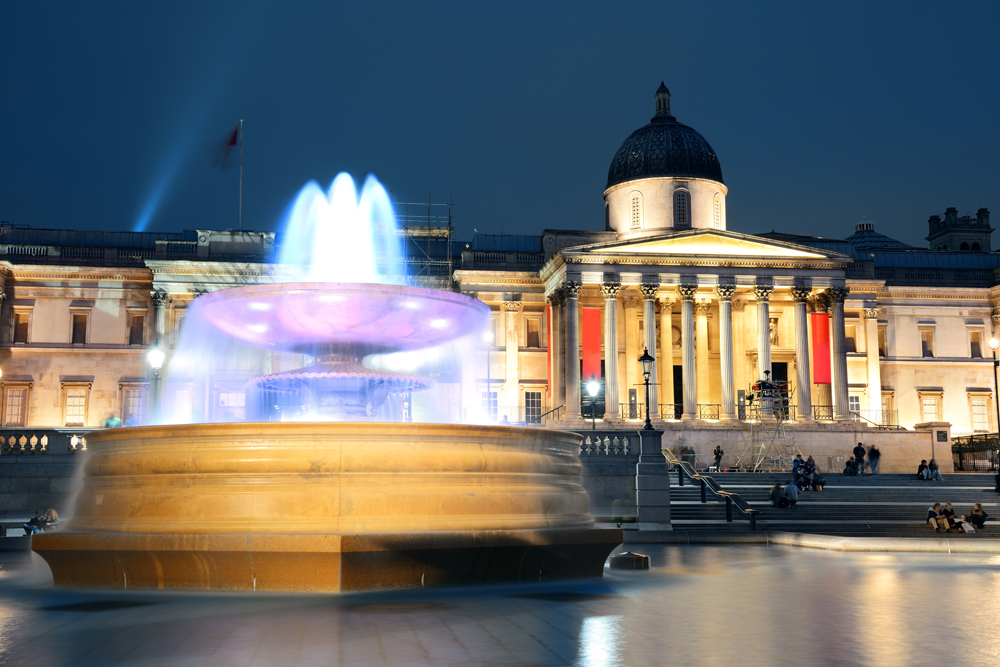 Trafalgar Square at night with fountain and national gallery in London