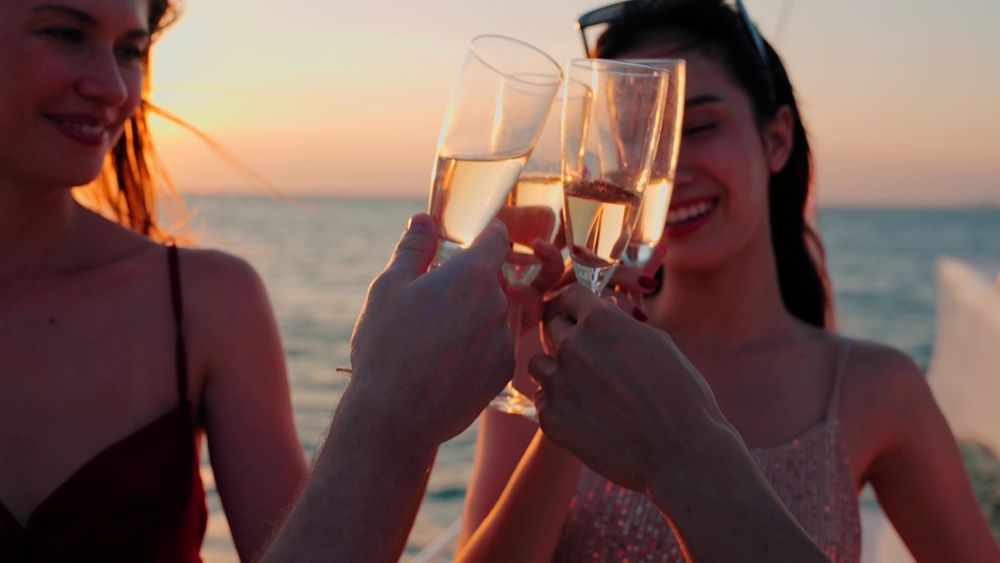 The 35th Anniversary Offer group on a boat drinking champagne